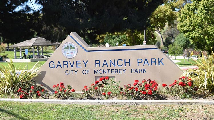 Garvey Ranch Park's observatory with a dome roof surrounded by trees and green lawn.