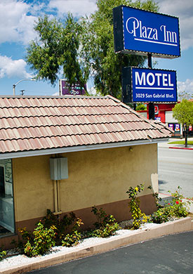 Courtyard view of Plaza Inn Motel Rosemead with outdoor seating area and lush greenery